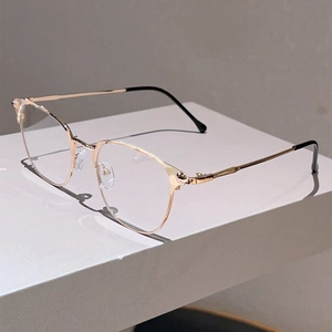Detail of rose gold metal eyeglasses frame with slim rims on a grey stone background