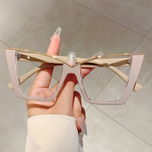 Fashionable oversized cat-eye glasses with pink frames and gold V-shaped metal trim