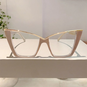 Detail of nude cat-eye glasses frame with gold metal top rim on white display stand