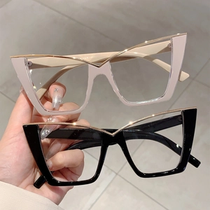 Detail of oversized cat eye glasses in beige and black with golden V-shaped metal accents