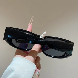 Close-up of black wide-temple rectangular sunglasses with glossy finish and polarized lenses
