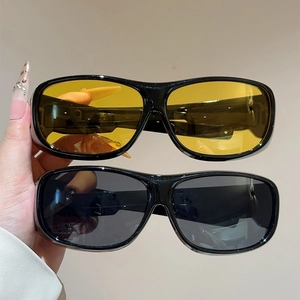 Close-up of wrap-around sports sunglasses with black and yellow lenses in black frames