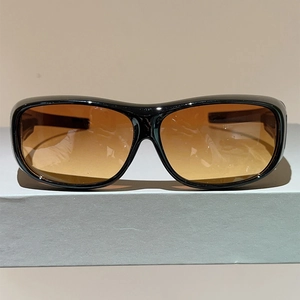 Detail view of large frame sports sunglasses with amber gradient lenses and black frames