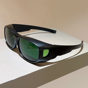 Professional black sports protective goggles with wide side shields and green lenses