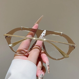 Detailed close-up of stylish aviator glasses with amber frames and gold metal top bar