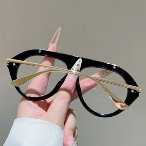 Detail view of black and gold oversized fashion frames with metal rivet accents