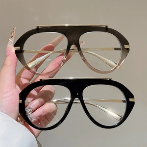 Detail of oversized retro aviator frames in gradient brown and glossy black finishes
