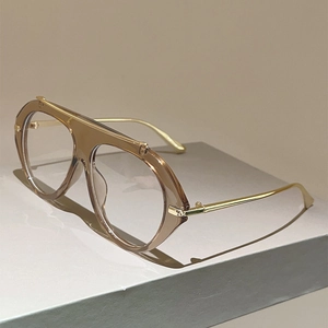 Detail of retro pilot glasses with tea brown frame and gold metal temples on a stand