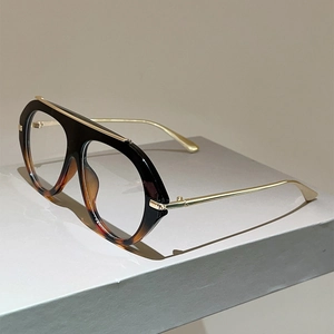 Detail of tortoise frame glasses with flat bridge and slim gold metal temples