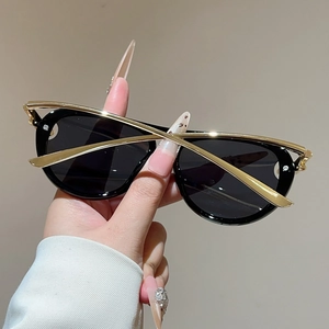 Detailaufnahme einer runden schwarzen Pilotenbrille mit Goldakzenten und dunklen Gläsern