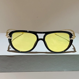 Detail der Pilotenbrille mit gelben Gläsern, Goldketten-Scharnieren und Metallbügeln