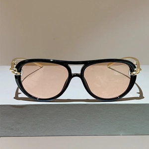 Detail einer Pilotensonnenbrille mit schwarzem Rahmen und goldener Kettendekoration
