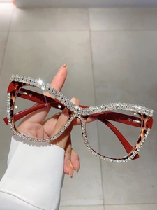 Macro detail of rhinestone-encrusted tortoiseshell cat-eye glasses frame and temple