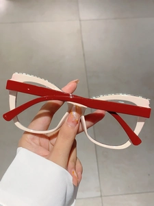 Detail of cream square glasses frame with rhinestones and contrasting red temples