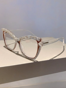 Detail of transparent cat-eye glasses frame with sparkling rhinestones and chain detail