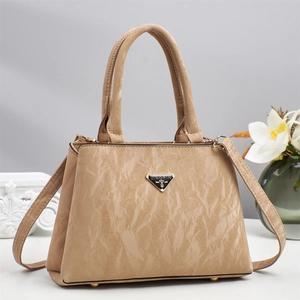 Detail der beige gefalteten Handtasche mit Metalllogo und stabilen Doppelgriffen