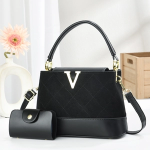 Elegant black handbag with gold V logo, stitched texture, and detachable shoulder strap