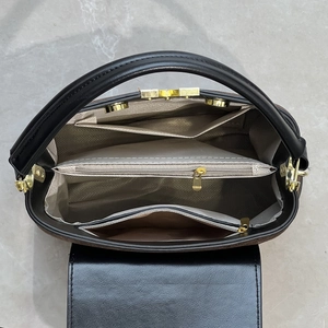 Detailed interior view of the brown suede and black leather handbag with zip compartments