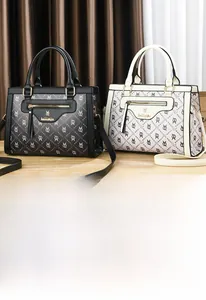 Détail de sacs fourre-tout en cuir à monogramme noir et crème avec poignées
