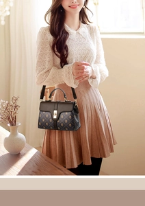 Detail of vintage brown monogram handbag with golden metal twist lock and sturdy handle
