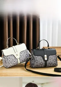 Detail of minimalist leather handbags in beige and black with metal turn-lock closures