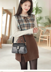 Close-up of geometric pattern shoulder bag with gold metal clasp on a stylish woman