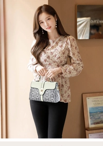 Fashionable woman holding black and white geometric pattern handbag with cream flap and lock