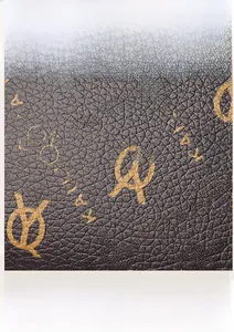 Detail of lychee textured leather fabric with golden symbolic prints on tote bag