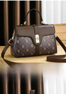 Detailed view of dark brown paneled leather tote with golden twist lock and logo print