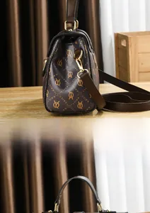 Side view of dark brown tote bag with gold hardware and logo monogram pattern