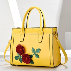 Elegant yellow patent leather handbag with red rose 3D applique and gold hardware details
