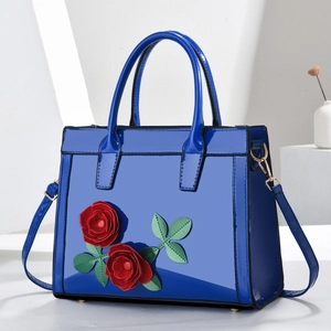 Blue patent leather handbag with red rose floral applique and round handles
