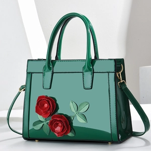 Close-up of forest green glossy tote bag with 3D red rose flowers and metallic feet