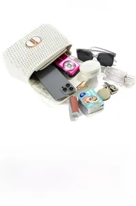Macro view of white quilted shoulder bag with metal lock showing large inner capacity