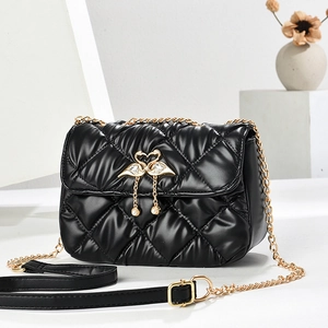 Quilted black shoulder bag with gold swan lock, pearl charm, and chain strap detail