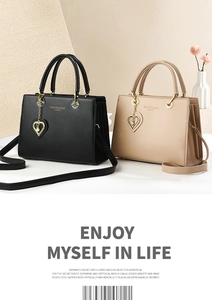 Detailed macro view of the fashion leather tote with elegant side accordion pleats and heart charm