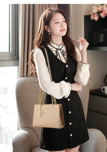 Detail of beige leather tote with golden heart pendant and fashion logo engraving