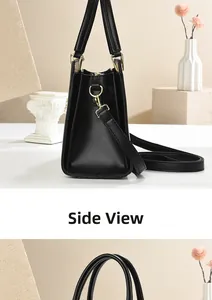 Side view of black leather tote bag showing gold hardware and trapezoid silhouette