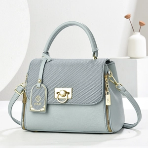 Elegant light blue-grey leather tote bag with woven flap and gold hardware accents