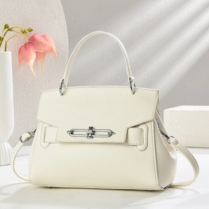 Minimalist beige pebble leather bucket bag with silver buckle and crossbody strap