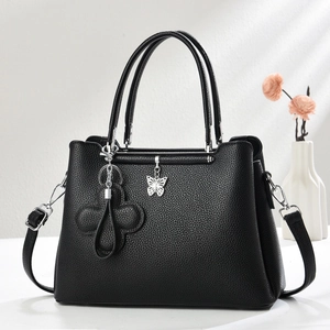 Elegant black lychee texture handbag with silver butterfly charm and shoulder strap