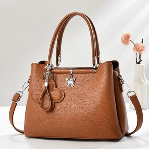 Brown lychee grain leather tote bag with silver butterfly charm and adjustable strap