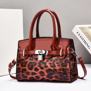 Elegant red patent leather handbag with leopard print panel and silver lock detail