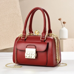 Elegant red leather handbag with pearl clasp and golden chain strap for versatile wear