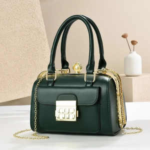 Elegant dark green leather handbag with a gold metal logo lock and large pearl clasp