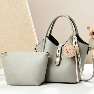 Light gray pebble leather bucket bag set with bear charm and golden twist lock