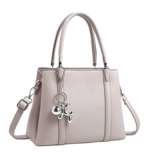 Beige pebble leather tote bag with a silver balloon dog charm and shoulder strap