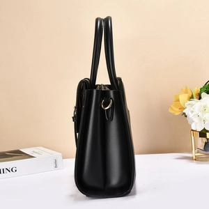 Detail view of the black leather handbag side profile showing the gusset structure