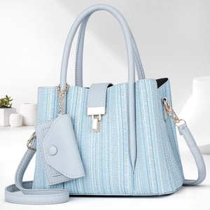 Detail of light blue crossbody bag featuring woven texture and a mini matching pouch
