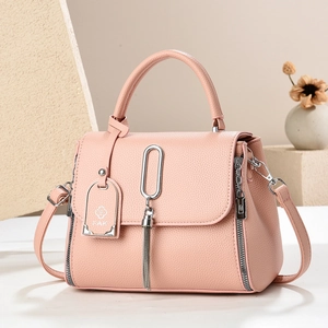 Roze shopper van leer met kiezelstructuur, zilveren details en kwastjes in een studio